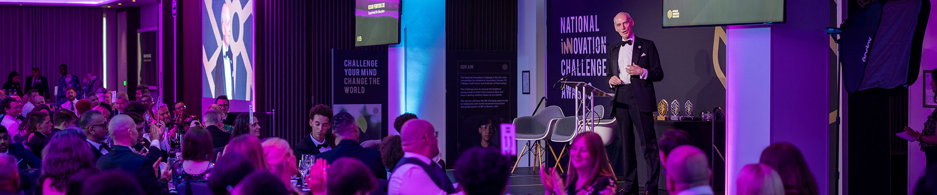 National Innovation Challenge Awards night with former Skills England Chair Richard Pennycook speaking on stage in front of the audience of guests and winners.