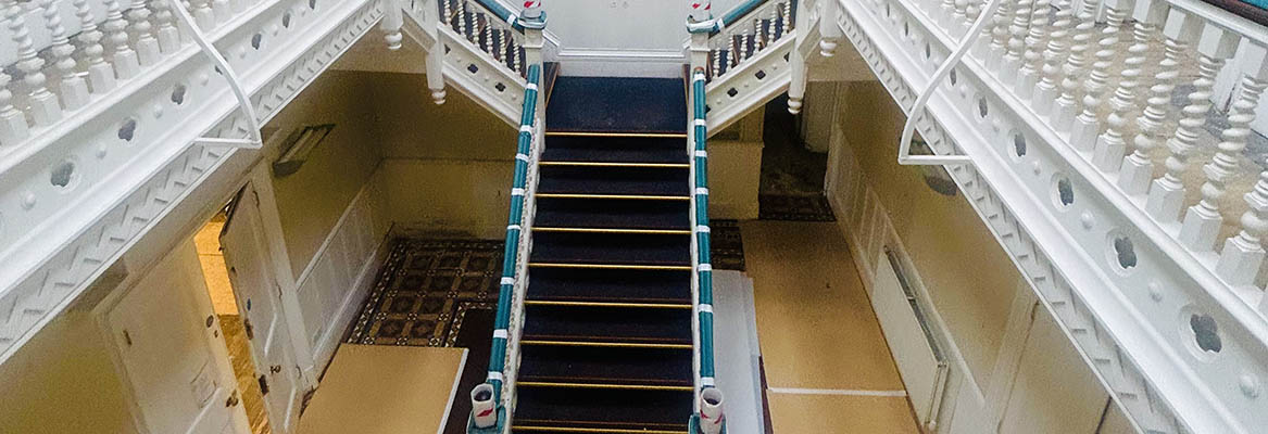 Barra Hall inside white staircase with balconies either side.