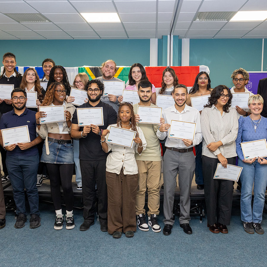 Harrow, Richmond and Uxbridge Colleges (HRUC) students who took part in the Turing Scheme Overseas Placements  in a group holding up their certificates and smiling. They are joined by Jo Withers, Liam Plumridge and Tim Wells.