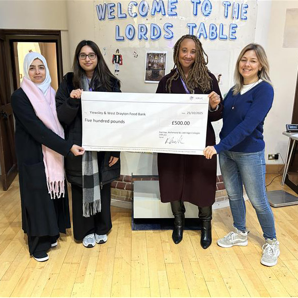 Sonia Lollia (Employee Experience Manager), Yashvi Prajapati (Employee Experience Administrator), Usha Chowdhury (Wellbeing and Inclusion Officer) presenting  a ceremonial cheque signed by HRUC CEO, Keith Smith, to Marianna Bahlay of Yiewsley and West Drayton Food Bank.