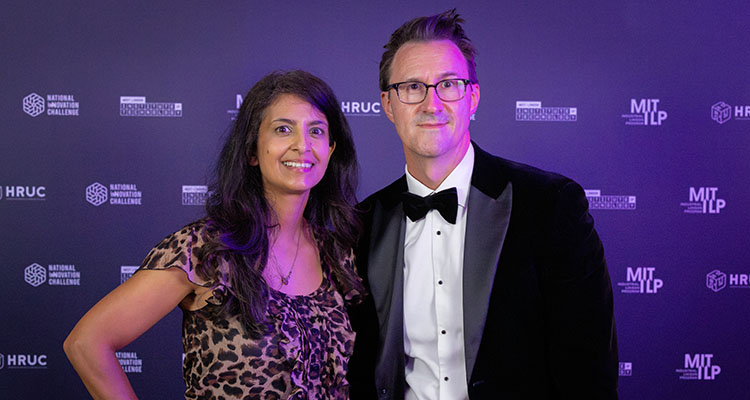 Former Blue Peter TV presenter, and STEM ambassador Konnie Huq with Keith Smith, CEO of HRUC - against a purple backdrop with logos at the NIC awards night.