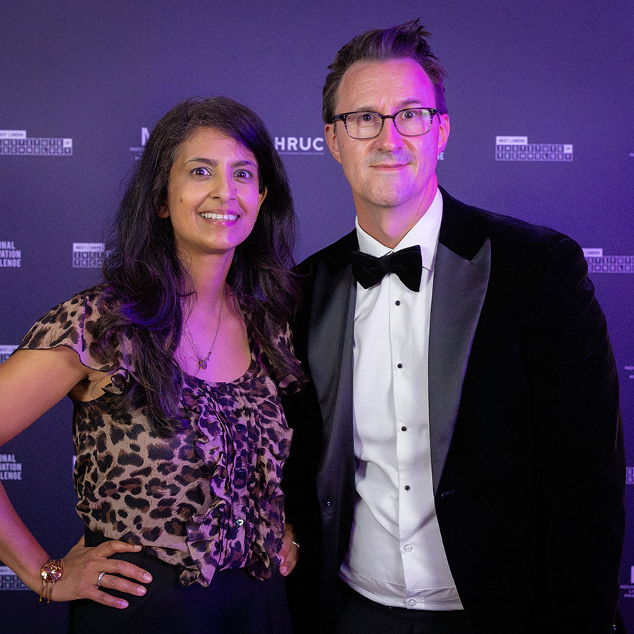 Former Blue Peter TV presenter, and STEM ambassador Konnie Huq with Keith Smith, CEO of HRUC - against a purple backdrop with logos at the NIC awards night.