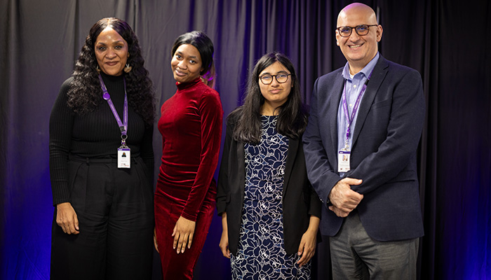 HRUC Skills Competition winners from Harrow College standing with Sultan Soukani and Kelly Ocloo, Assistant Principals, on stage, in front of a purple curtain. 