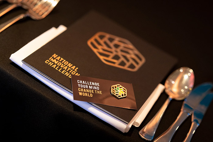 National Innovation Challenge badge and and programme on the table setting
