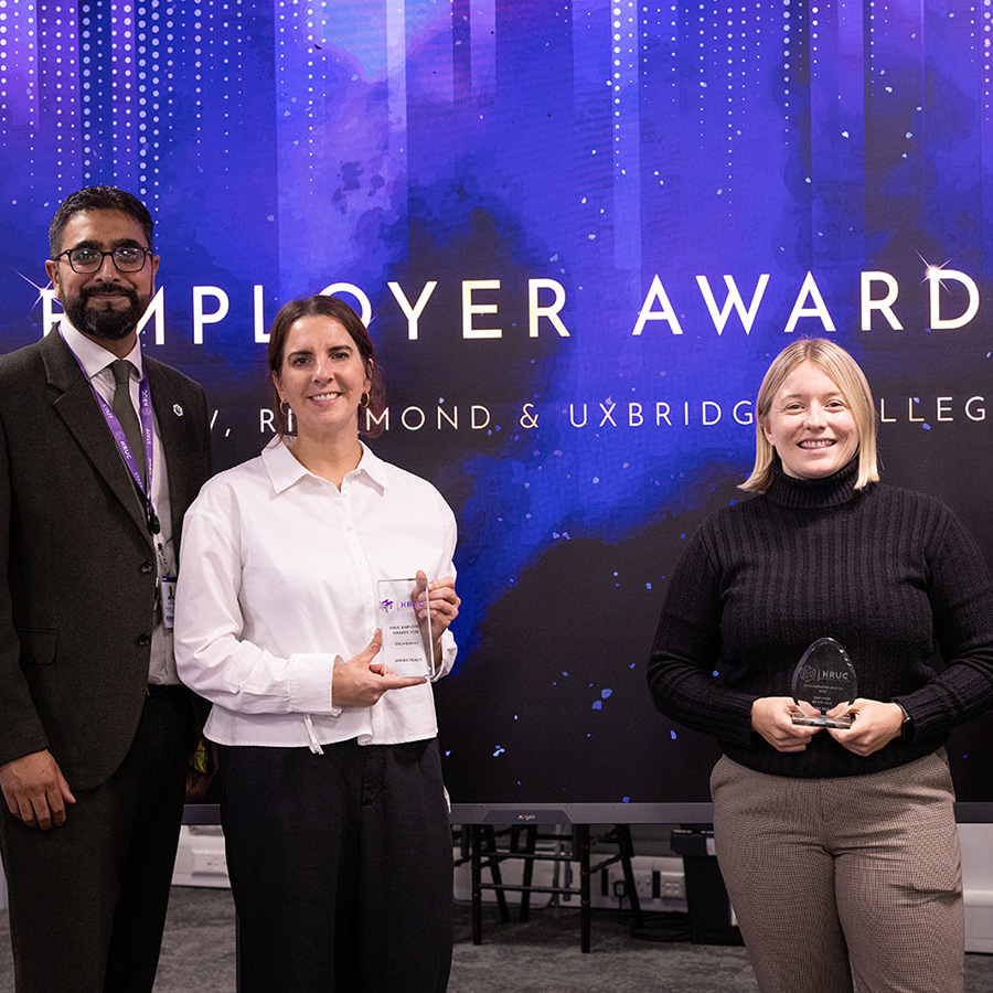 Yaseen Akhtar, Managing Director of the West London Institute of Technology, HRUC standing with two female representatives from AtkinsRéalis and Asif Khan -Assistant Principal - IoT, Engineering and Technologies. The two women are holding awards for HRUC Employer of the Year and Engineering Employer of the Year. They are at the Employer Awards evening at Uxbridge College and there is a sparkly blue backdrop behind them.
