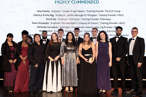 A group of HRUC apprentices and others standing on stage who were shortlisted as finalists and awarded Highly Commended at the 2026 West London Business Awards. They are all dressed in evening wear with a large white screen behind them that lists their names and award.  