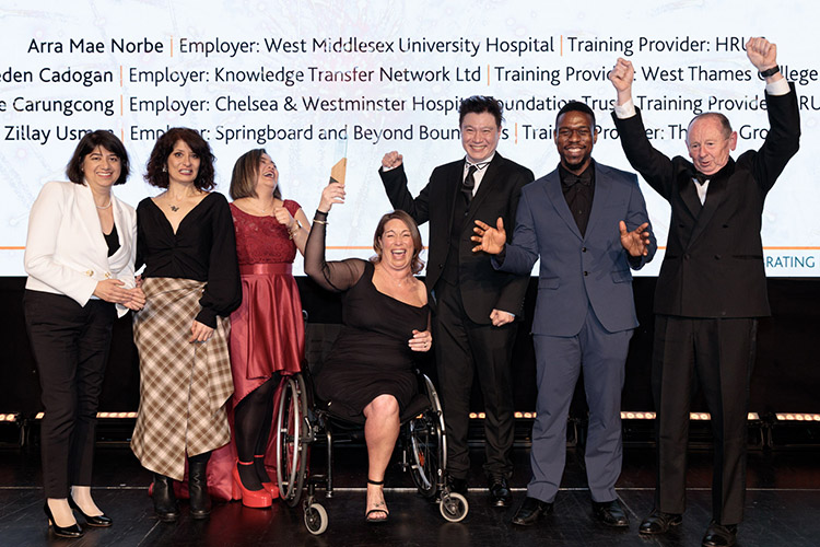 Apprentice of the Year Winner – Joanne McSweeney holding her award and cheering with others on stage at the 2026 West London Business Awards.