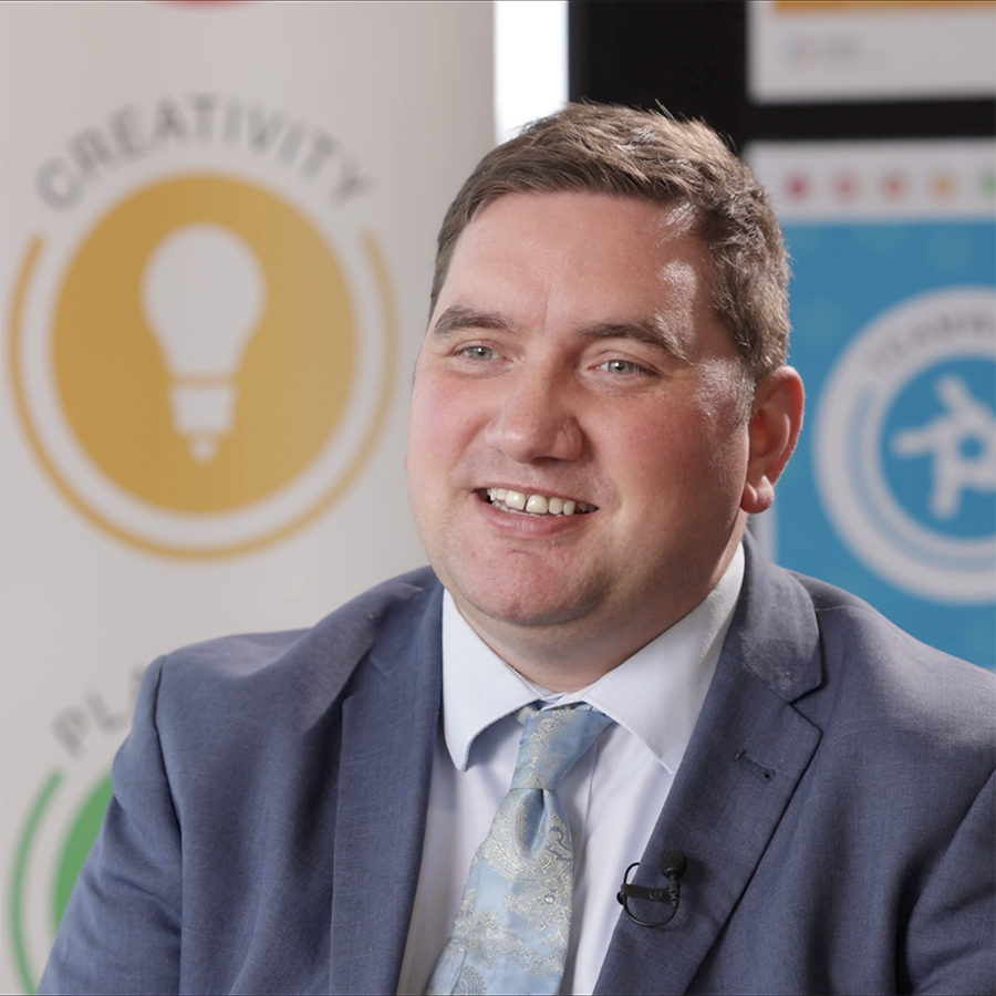 Liam Plumridge, HRUC’s Assistant Director for Enhanced Skills and Employability. He is wearing a grey suit, white shirt and light blue tie.