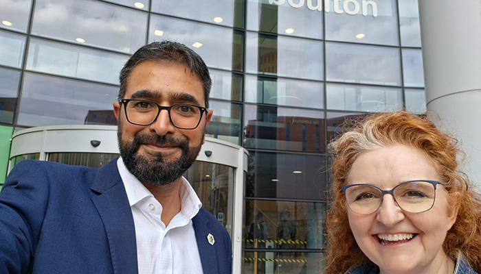 Yaseen Akhtar, Managing Director of the West London Institute of Technology, and Dr Niamh Shaw, NIC ambassador in front of Matthew Boulton College. There is a large glass wall behind them that is the front of the college.
