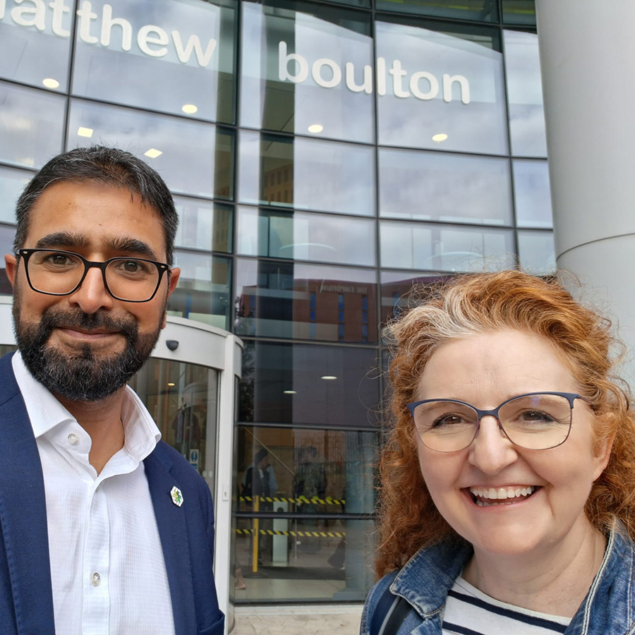 Yaseen Akhtar, Managing Director of the West London Institute of Technology, and Dr Niamh Shaw, NIC ambassador in front of Matthew Boulton College. There is a large glass wall behind them that is the front of the college. 