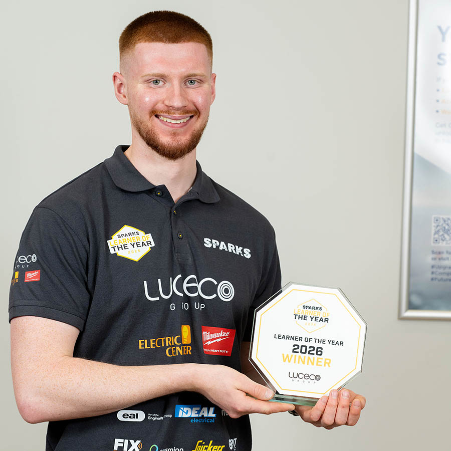 Samuel Stevely - SPARKS Learner of the Year 2026 - holding his award and wearing a black polo shirt with brands and logos on it.