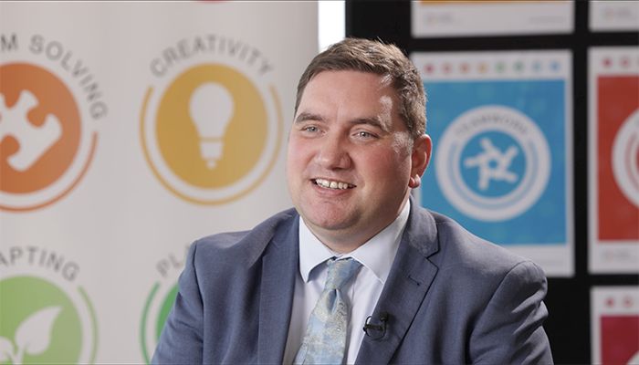 Liam Plumridge, HRUC’s Assistant Director for Enhanced Skills and Employability. He is wearing a grey suit, white shirt and light blue tie.