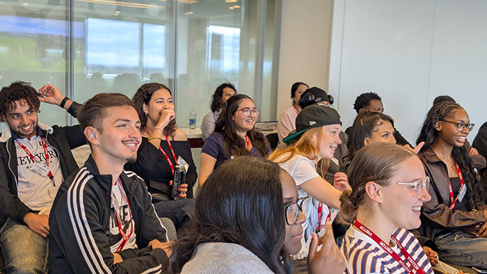 The audience of students at the celebration of the Turing Scheme over the 2025/26 academic year. They are seated, smiling and watching somthing.